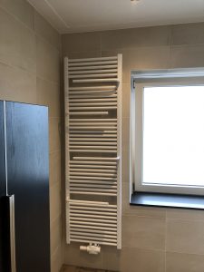 Badkamer renovatie Leusden radiator aan muur met haken voor handdoeken